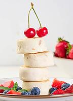 A stack of four cheesecakes on a plate with berries, blueberries, strawberries and cherries. Background white [IBR125344332]
