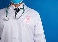 Pink silk ribbon attached to a white medic coat, symbol of the fight against breast cancer in October [IBR125363549]