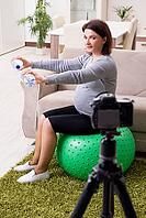 Pregnant blogger doing physical exercises [IBR125363578]