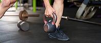 When lifting a kettlebell, a person shows the correct shape and emphasizes strength and fitness in a fitness atmosphere [IBR125363608]