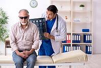 Old man visits young male doctor [IBR125382573]