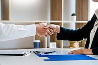 Businessman and businesswoman handshaking over the office desk after Greeting new colleague, business meetings concept [IBR125382578]