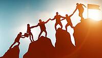 Concept of teamwork with the team climbing the mountain summit [IBR125382581]