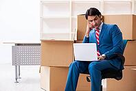 Young handsome businessman moves to a new job [IBR125382589]
