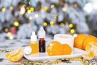 Handmade soap in the form of Orange tangerine with bottles of dye, flavor, a block of glycerin soap base, silicone mold, on background of Christmas tree with golden light. Soap as gift new year [IBR125382593]