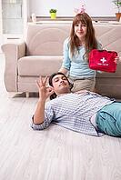 The young couple in a first aid concept at home [IBR125382614]