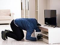 The burglar steals television from the house [IBR125382621]