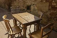 A Vintage Table And Four Chairs On A Street In Ancient Certaldo, Tuscany [IBR125382626]