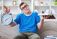 The young student is preparing for exams and studying on a sofa at home [IBR125382639]