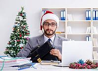 The young businessman is celebrating Christmas in the office [IBR125382650]