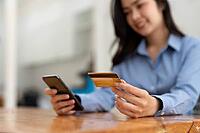 Young woman has a credit card and uses her smartphone for online shopping. Online Payment Shopping Concept [IBR125382658]