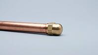 A capped copper pipe section with a smooth metal end cap and even exterior surface, no visible marks or moisture, on a plain grey studio background, close-up product shot, AI generated [IBR125395939]
