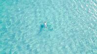 Young man snorkeling with mask in crystal clear turquoise sea water, enjoying summer vacation, underwater adventure and outdoor leisure activity [IBR125405039]