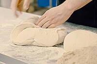 Rolling out the dough with your hands, flour and white dough [IBR125405044]