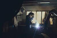 A welder in a workshop welds a part [IBR125405066]