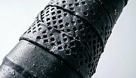 Extreme close-up of black perforated tennis racket grip tape texture with spiral wrap and overlapping seam, raking studio light, full frame texture, sports equipment concept, AI generated [IBR125407383]