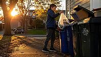 Young boy recycling at bins during sunset in an autumn neighborhood setting. Recycling, AI generated [IBR125407389]