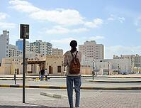 Female tourist with backpack on Arab roads in the old town of Sharjah, United Arab Emirates [IBR125411069]