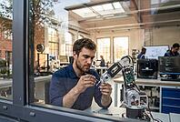 Robotics engineer assembling automated mechanical arm prototype in high tech workshop, artificial intelligence hardware engineering development, mechatronics calibration in smart manufacturing innovation lab, concentrated technician adjusting precision co [IBR125414120]