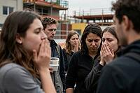 Shocked young people experiencing collective trauma and grief at an urban accident scene, horrified witnesses covering their mouths in utter disbelief, emotional distress among bystanders observing an unexpected tragedy, existential angst and social vulne [IBR125414125]