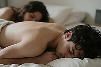 Deep restorative sleep of a young couple lying in white bed sheets, somatic relaxation, peaceful slumber in morning light, vulnerable intimacy, circadian rhythm regeneration, bare skin texture emphasizing somatic grounding, tranquil domestic bedroom envir [IBR125414130]