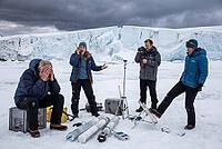 Polar research team facing ecological tipping point and climate crisis, distress among glaciologists observing calving glacier, ice core samples resting on subzero snow beside field sensors, a frustrated researcher kicking over tripod measuring apparatus, [IBR125414142]
