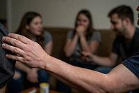 Emotional disclosure and interpersonal communication dynamics within a supportive youth peer group, tactile gesture of empathy during group therapy, reaching arm symbolizes active listening and psychological intervention, shocked facial expression of an a [IBR125414148]