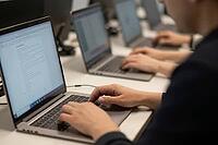 Digital workforce collaborating on portable computers during technical training, hands typing code and analyzing complex data in corporate office space, cognitive labor in modern knowledge economies, anonymous individuals engaged in software development a [IBR125414184]
