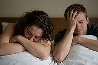 Emotional alienation and marital conflict in domestic space, desperate couple lying frustrated in bed under psychological distress and mental burden, somber morning light illuminates the physical proximity yet profound emotional detachment between partner [IBR125414190]