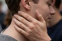 Tactile intimacy, emotional support and somatic connection, a caring hand gently caressing a young man neck and jawline, nonverbal communication of trust and vulnerability through skin contact, somatic nervous system regulation through physical presence a [IBR125414197]