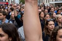 Erection of a raised arm amidst a dense assembly of citizens marching for democratic freedom, collective solidarity and socio political transformation in the urban space, anonymous activists uniting during a street demonstration to voice resistance agains [IBR125414203]