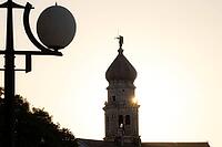 Sunrise behind the bell tower of the Assumption Cathedral with baroque onion dome and trumpet blowing angel, old town of Krk, island of Krk, Croatia [IBR125415365]