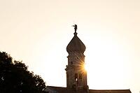 Sunrise behind the bell tower of the Assumption Cathedral with baroque onion dome and trumpet blowing angel, old town of Krk, island of Krk, Croatia [IBR125415379]