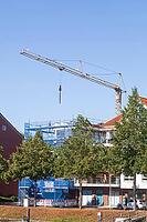 Shell of a residential building with scaffolding, construction crane and blue safety net, residential construction, Emden, East Frisia, Lower Saxony, Germany [IBR125415400]