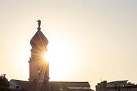 Sunrise behind the bell tower of the Assumption Cathedral with baroque onion dome and trumpet blowing angel, old town of Krk, island of Krk, Croatia [IBR125415404]