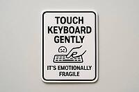 Close up of a funny sign recommending to touch keyboard gently because it's emotionally fragile, AI generated [IBR125421205]