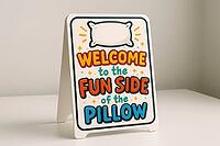 Tabletop sign with the message welcome to the fun side of the pillow promoting relaxation, comfort, and good sleep, AI generated [IBR125421209]