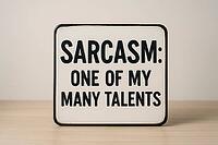 White sign with black writing placed on a wooden table, displaying the funny quote sarcasm, one of my many talents, AI generated [IBR125421239]