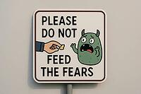 Sign featuring a hand offering food to a scared monster, symbolizing the concept of not feeding fears and promoting courage, AI generated [IBR125421260]