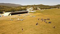 Gliders and people near hangars on an airfield, with hills in the distance, - dp - Aérodrome de Château-Arnoux - Saint-Auban, France [IBR125421644]