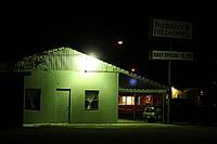 A lone cheap motel, with a neon green glow at night, featuring a diner sign and a parked car, Salton Sea, California, USA [IBR125421671]