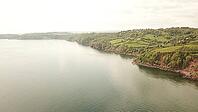 Tranquil coastal scene viewed from above, with calm waters and lush greenery, - Drone photography - South coast of Devon, England, UK [IBR125421678]