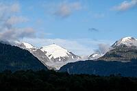 Glaciated impressive mountain peak, mountains with forest, Carretera Austral, near Villa Santa Lucia, Los Lagos, Chile [IBR125423469]