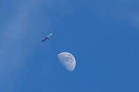 Airbus jet commercial passenger aircraft of Wizzair airlines flying in a blue sky with the moon in the background, England, United Kingdom [IBR125423479]