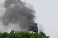 Thick black smoke spewing from an industrial chimney above green trees Sreepur, Gazipur, Bangladesh [IBR125423491]