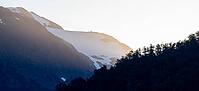 Mountains with forest and glaciated mountain peaks at sunrise, Carretera Austral, near Villa Santa Lucia, Los Lagos, Chile [IBR125423506]