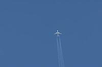 Jet commercial passenger aircraft flying in a blue sky with contrails or vapour trails behind in the atmosphere, England, United Kingdom [IBR125423512]