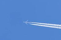 Jet commercial passenger aircraft flying in a blue sky with contrails or vapour trails behind in the atmosphere, England, United Kingdom [IBR125423517]