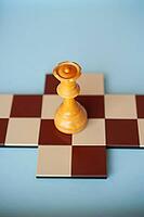 A single queen on a small chessboard with a light blue background [IBR125424521]