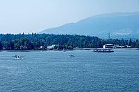 Multiple seaplanes are visible on the water with a lush green forest and mountains in the background, Canada place, North Vancouver, BC Canada [IBR125424531]